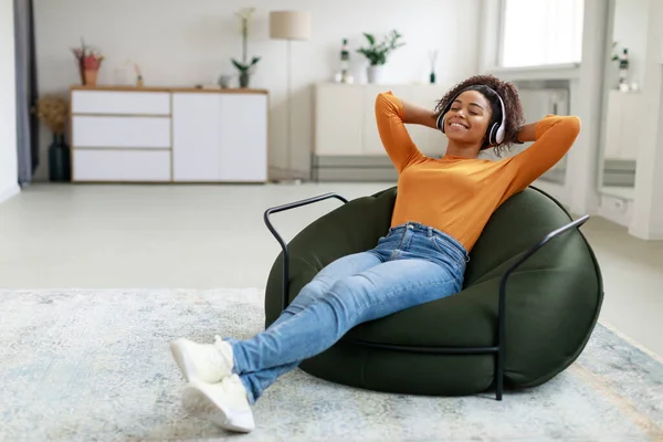 Calm black woman having rest at home on bean bag — Stockfoto