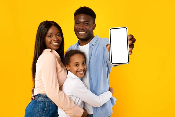 黒の家族は、モックアップのための空白のスマートフォン画面を示す — ストック写真