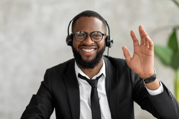 Hombre afroamericano en auriculares saludando mano a cámara —  Fotos de Stock
