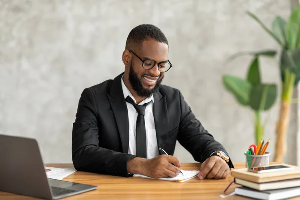 Hombre afroamericano usando la escritura portátil en el cuaderno — Foto de Stock