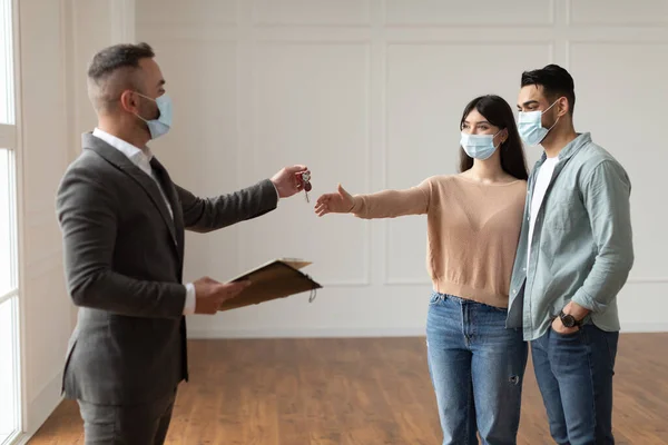 Real Estate Agent In Facemask Giving Keys To Excited Buyers —  Fotos de Stock