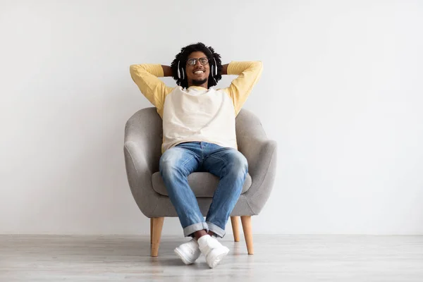 Relax Mode. Young Black Guy Wearing Wireless Headphones Resting In Armchair — Stockfoto