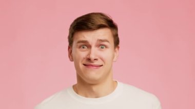 Disgusted Millennial Guy Frowning Posing Over Pink Background, Studio Shot