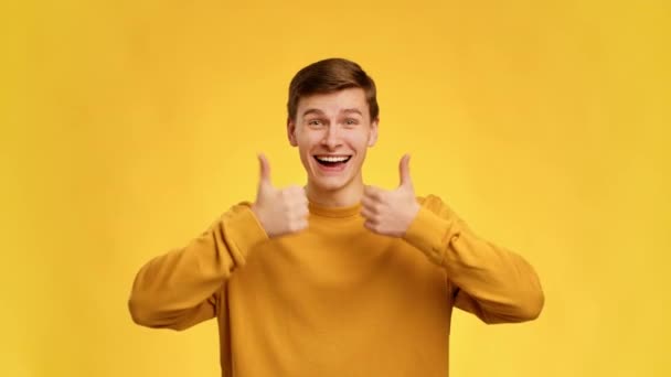 Man Gesturing Thumbs Up With Both Hands Over Yellow Background — Vídeo de Stock
