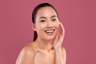 Sensual beautiful asian lady posing topless on studio background