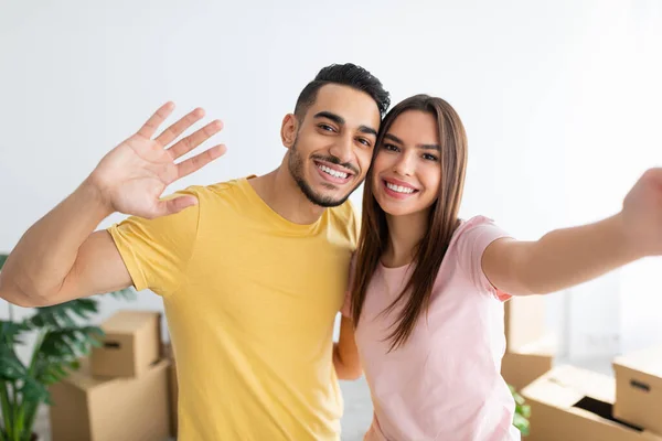 Beautiful Caucasian woman with her Arab husband taking selfie, moving to new house together — Stockfoto