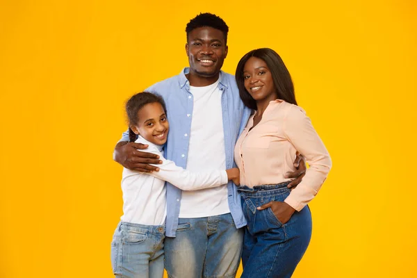 Gelukkig zwart guy poseren met vrouw en glimlachen tiener dochter — Stockfoto