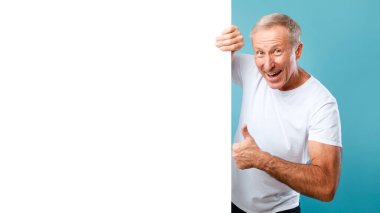 Mature man peeking out blank white advertising billboard showing like