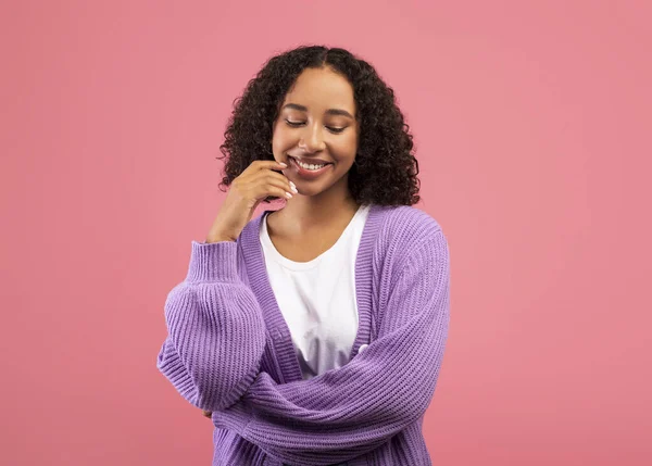 Thoughtful black woman touching chin and looking aside, considering interesting offer, standing over pink background — Stock fotografie