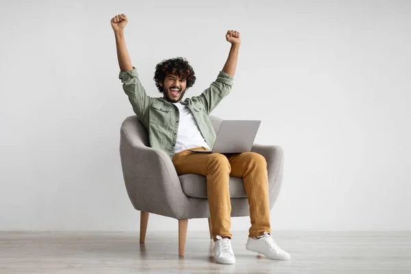 Emotional hindu guy with laptop celebrating success — Stock Fotó