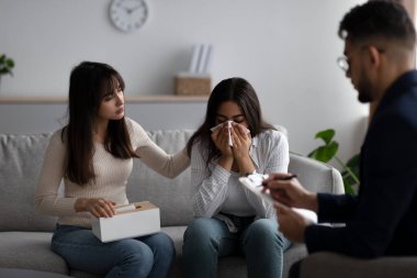 Homosexual marriages problems. Young middle eastern woman crying, lesbian couple consulting phychologist
