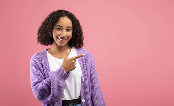 Check this offer. Happy black woman pointing at copy space, looking and smiling at camera over pink studio background — Foto de Stock