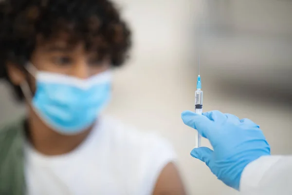 Шприц з вакциною в невпізнаваній руці лікаря — стокове фото