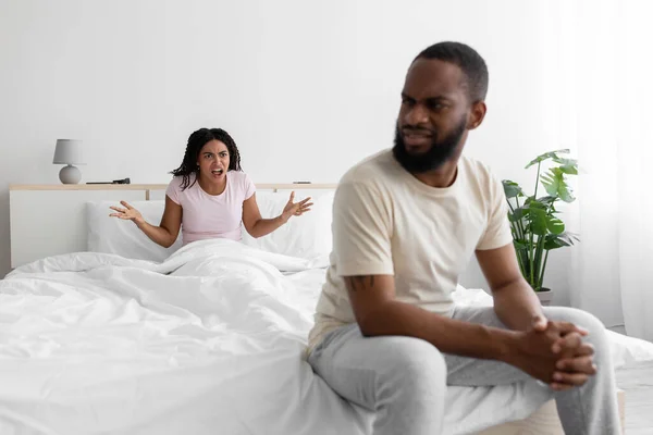 Sad young black man listen wife, woman freaking out and yells at unhappy husband, swear in bedroom interior — Stok fotoğraf
