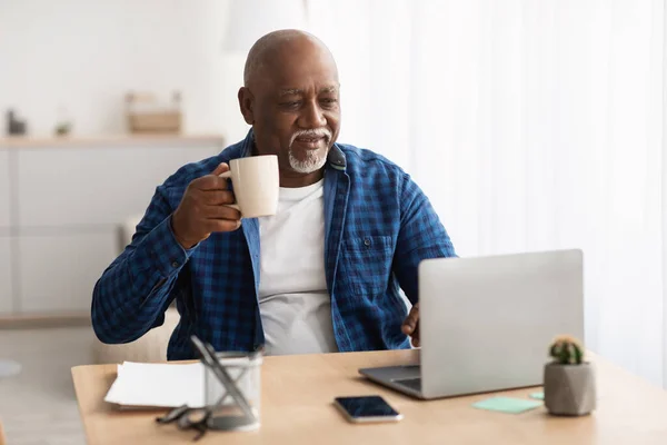 職場でノートパソコンでコーヒーを飲む黒人熟女 — ストック写真