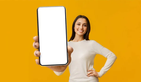 Mobile app mockup. Happy woman showing big cellphone with white blank screen, lady demonstrating space for ad — Stockfoto