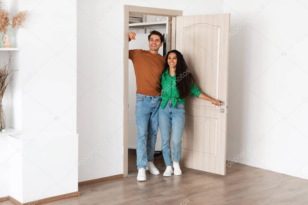 Portrait of excited emotional couple walking in their apartment