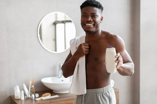 Smiling Black Male Showing Shower Gel Bottle Standing In Bathroom — ストック写真