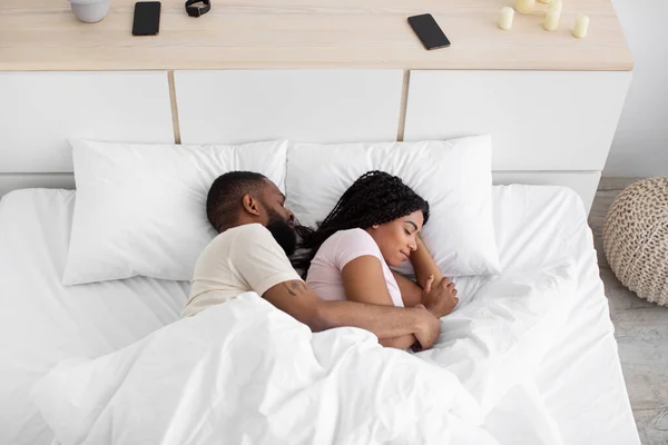 Millennial black lady and man lie on white soft bed, hugging, sleeping and relax at night in bedroom interior — Stok fotoğraf