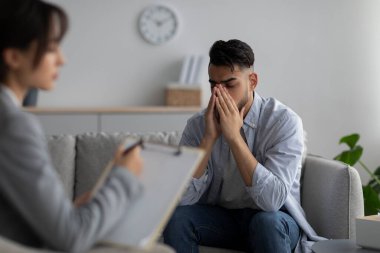 Psychotherapy, treatment of depression and anxiety concept. Stressed man having session at psychologists office