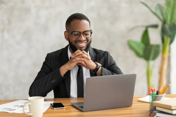 Усміхнений чорний чоловік дивиться відео на комп'ютер — стокове фото