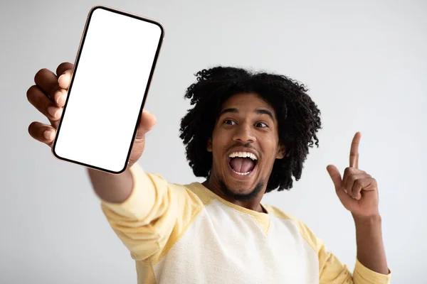 Online Offer. Joyful Black Male Holding Blank Smartphone And Raising Finger Up — Fotografia de Stock