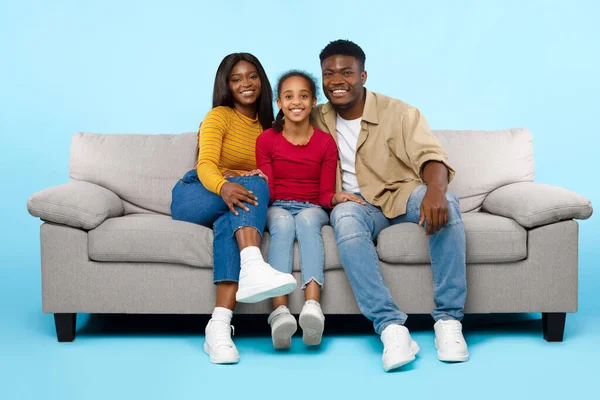 African American girl posing with her smiling mom and dad — стоковое фото