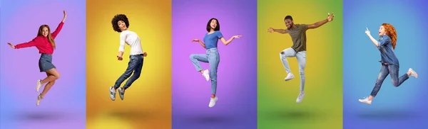 Full length of millennial international people jumping together, smiling at camera over bright neon studio backgrounds — Stockfoto