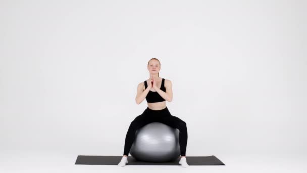 Αθλητική Millennial γυναίκα άσκηση με Fitball πάνω από λευκό φόντο στο στούντιο — Αρχείο Βίντεο