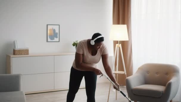Black Lady Cleaning House Mopping Floor Wearing Headphones Indoor — Stockvideo