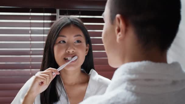 Young Korean Spouses Brushing Teeth Smiling Standing In Bathroom — Stockvideo