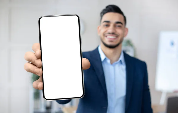 Hombre de negocios árabe guapo mostrando Smartphone con pantalla blanca en blanco en la cámara — Foto de Stock