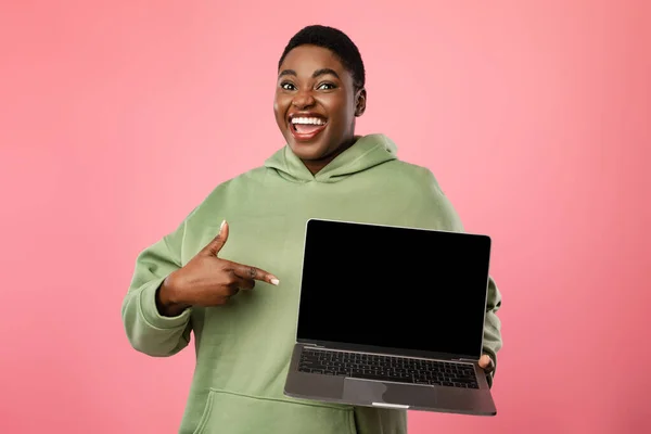 African Woman Pointing Finger At Laptop Empty Screen, Pink Background — Fotografia de Stock