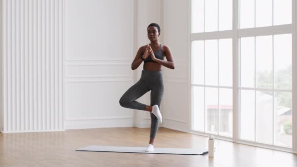 Sporty Black Female Practicing Yoga At Home, Standing In Tree Pose — Stok video