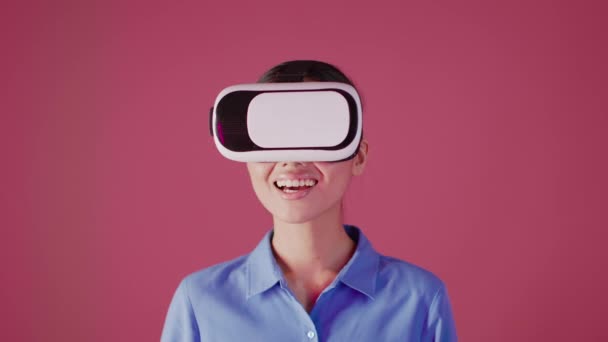 Excited Asian Woman Wearing VR Headset Experiencing Virtual Reality Over Pink Background — Stock Video