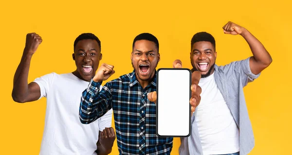 Emotional black guys gambling online, showing smartphone, mockup — Stok fotoğraf