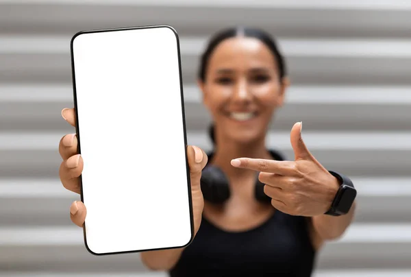 Fitness App. Sporty Young Woman Pointing At Big Blank Smartphone In Hand — Stok Foto