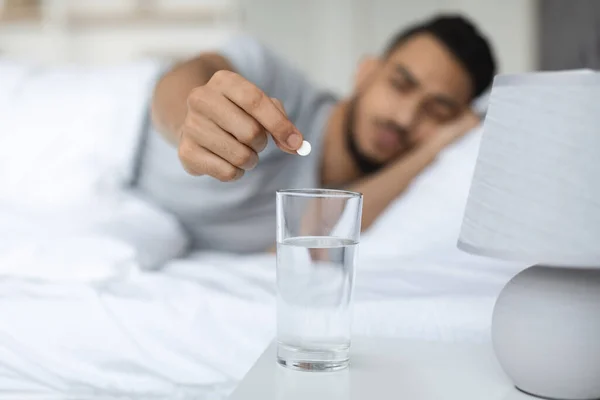 Arab Man Putting Pill Into Glass Of Water Standing On Bedside Table — Fotografia de Stock