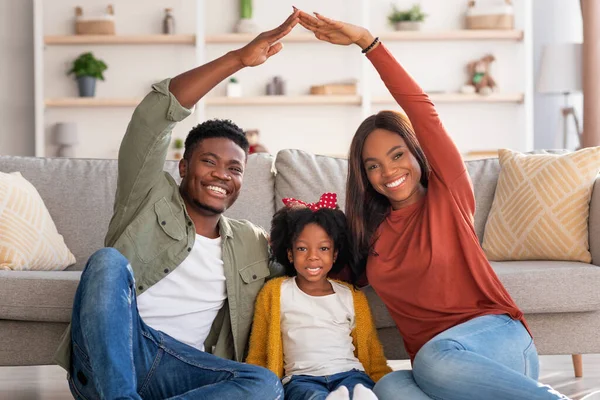 Family Housing. Black Parents Making Symbolic Roof Of Hands Above Little Daughter — Foto de Stock