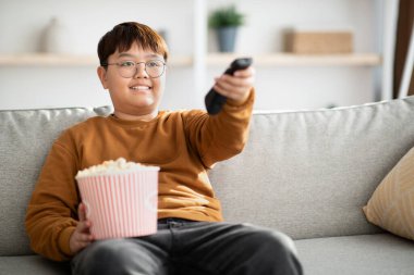 Relaxed chinese kid watching TV at home