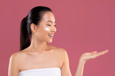 Happy asian woman holding something invisible on her palm