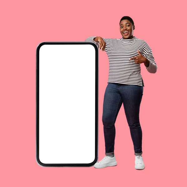 Black Female Posing Near Big Smartphone Pointing Finger, Pink Background — Photo