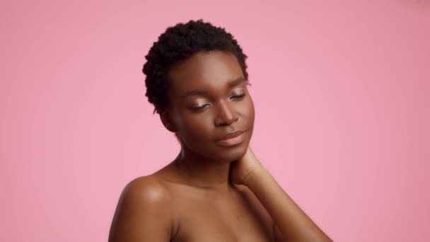 Sensual African Female Stroking Chest And Neck On Pink Background — стоковое видео