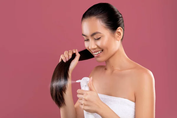 快乐的长发亚洲女人用发胶喷紫色 — 图库照片