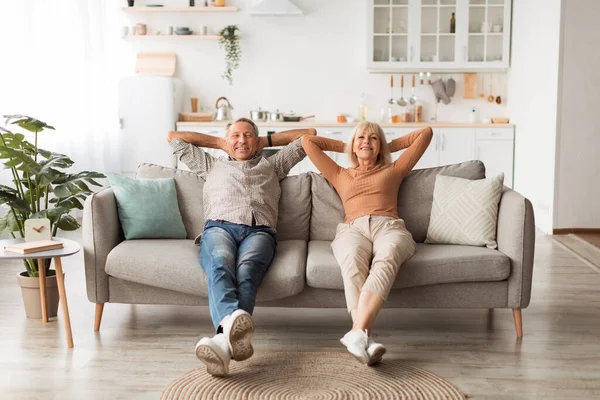 Щаслива зріла пара сидить на дивані розслабляючий відпочинок вдома — стокове фото