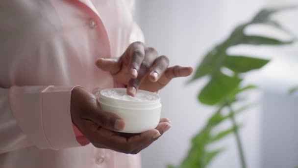 African Lady Holding Facial Cream Jar Moisturizing Skin Indoor, Cropped — Vídeos de Stock