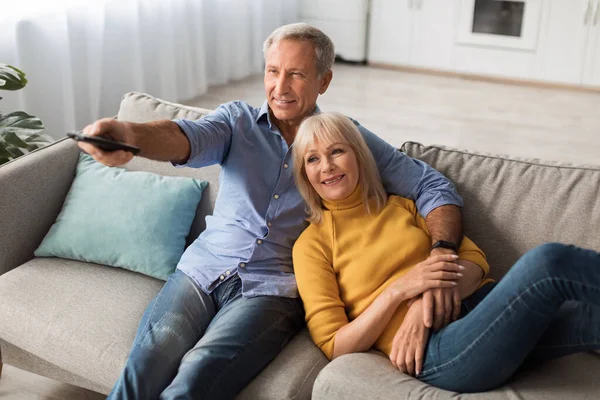 Happy Senior Spouses Watching TV Relaxing At Home — Stok fotoğraf
