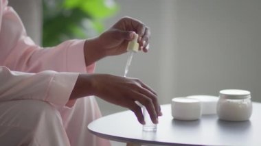 Unrecognizable Black Lady Applying Serum On Hand Moisturizing Skin Indoor