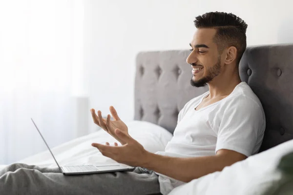 Online Communication. Young Arab Man Making Video Call With Laptop In Bed — Zdjęcie stockowe