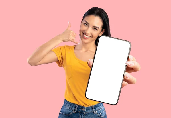 Attractive young woman holding smartphone with empty screen, mockup — Stok fotoğraf